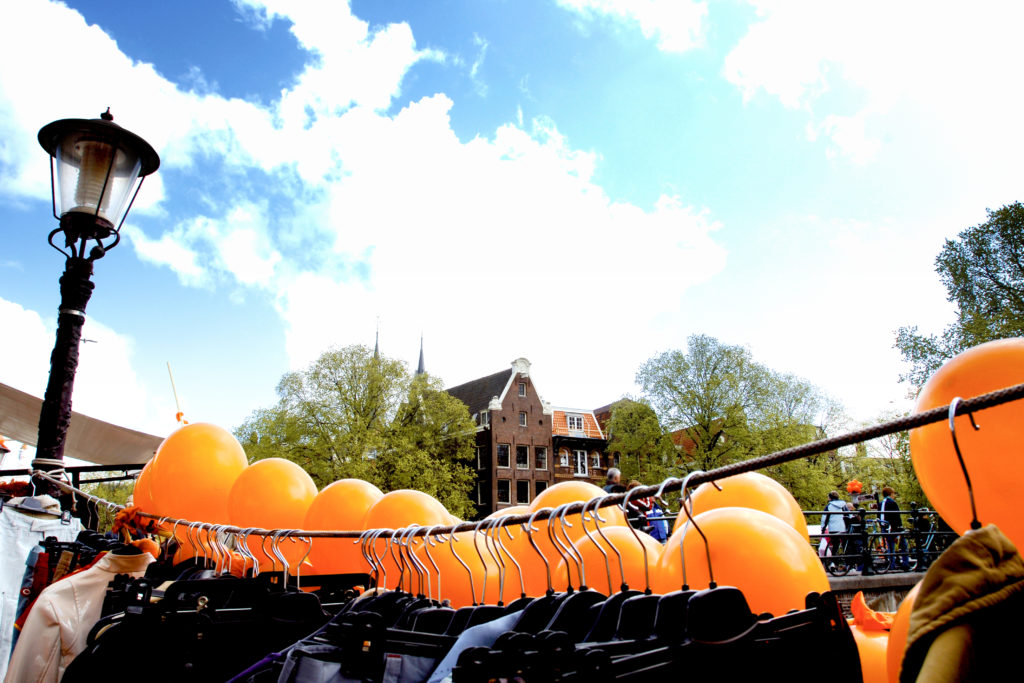 Orange balloons and a rack of old clothes for sale on King's Day in Amsterdam in the Netherlands