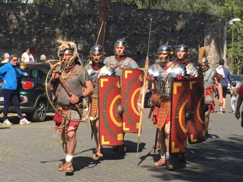 People dressed up as Roman centurions (soldiers) and marching on the Appian Way outside Rome in Italy.
