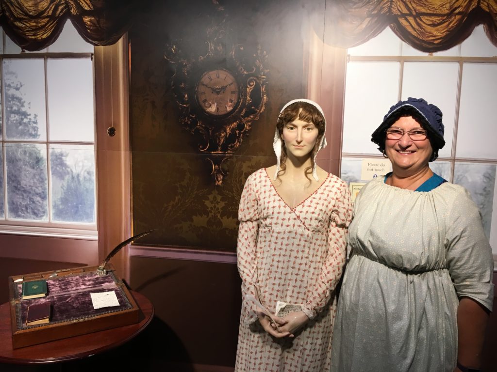 Author Carol Cram next to a statue of Jane Austen while traveling in Bath, England