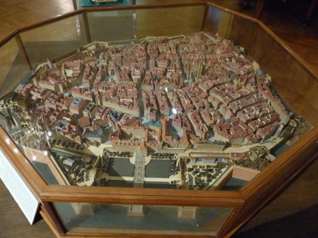 A detailed scale model of Vienna, showcasing the city's historic architecture, winding streets, and bridges over a river. The model is housed in an octagonal glass case, highlighting intricate features such as buildings, city walls, and surrounding greenery. This model is a highlight of a visit to the Wien Museum in Vienna.






