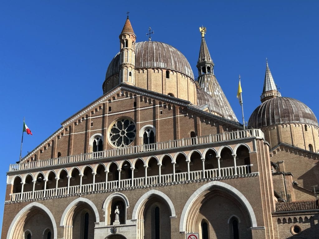 The Basilica of Saint Anthony in Padua, showcasing its majestic domes and intricate architecture under a clear blue sky. A top attraction for those discovering Padua's rich heritage.