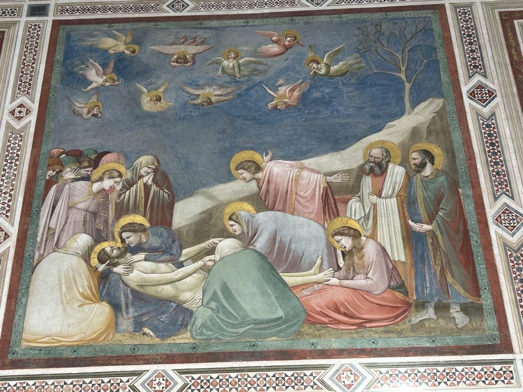 A fresco by Giotto in the Scrovegni Chapel, depicting the lamentation of Christ with vivid expressions and rich colors. A must-see for art lovers in Padua.