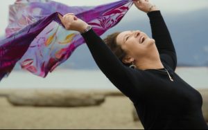 Carol Cram on the beach looking joyous