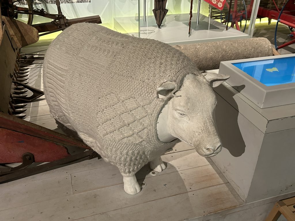 A large stuffed sheep wearing an Aran sweater