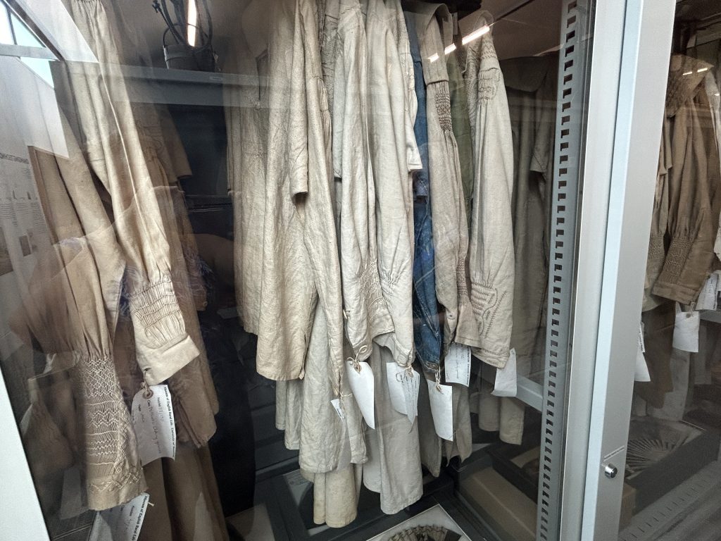 Several smocks hanging in open storage at the Museum of Rural Life