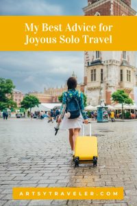 Picture of a woman wheeling a yellow suitcase over a cobbled street meant to represent a city in Europe. The text above the picture is "My Best Advice for Joyous Solo Travel".