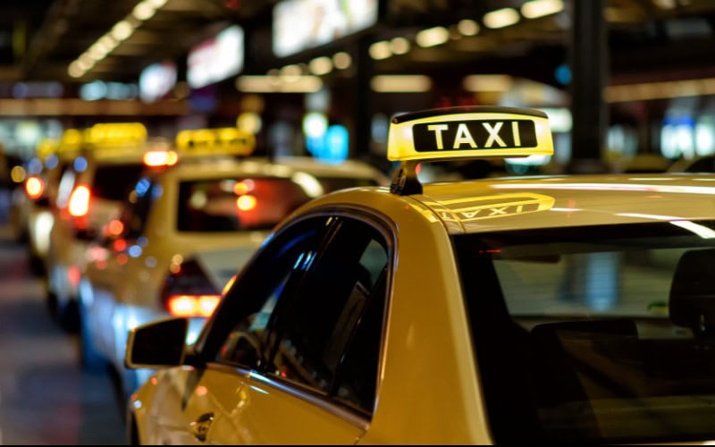 A row of taxis at night.