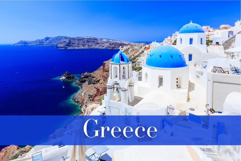 The blue-domed churches of Oia in Santorini, Greece, overlooking the deep blue Aegean Sea and rugged volcanic cliffs, with whitewashed buildings bathed in sunlight.