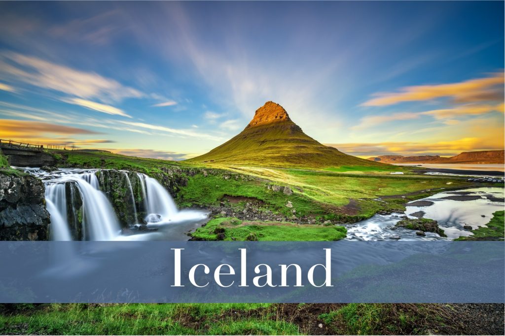 The striking Kirkjufell mountain in Iceland with a cascading waterfall in the foreground, surrounded by lush green grass, and a sky streaked with soft golden and purple hues.