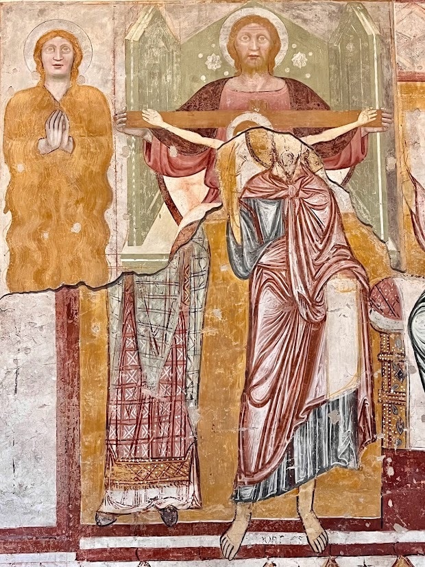 Ancient fresco depicting religious figures, including Jesus, with earthy tones and intricate details.