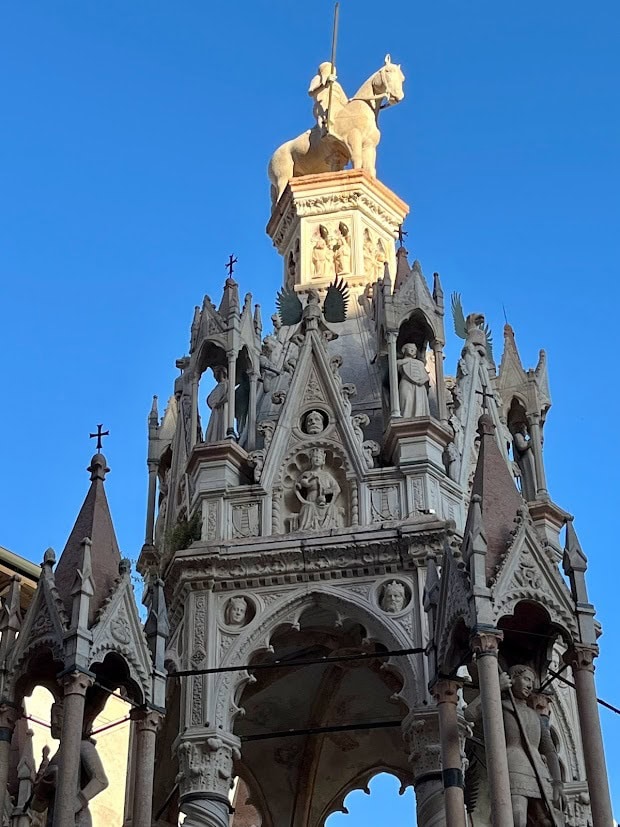 An ornate Gothic monument adorned with sculptures and pinnacles, topped with a statue of a knight on horseback.