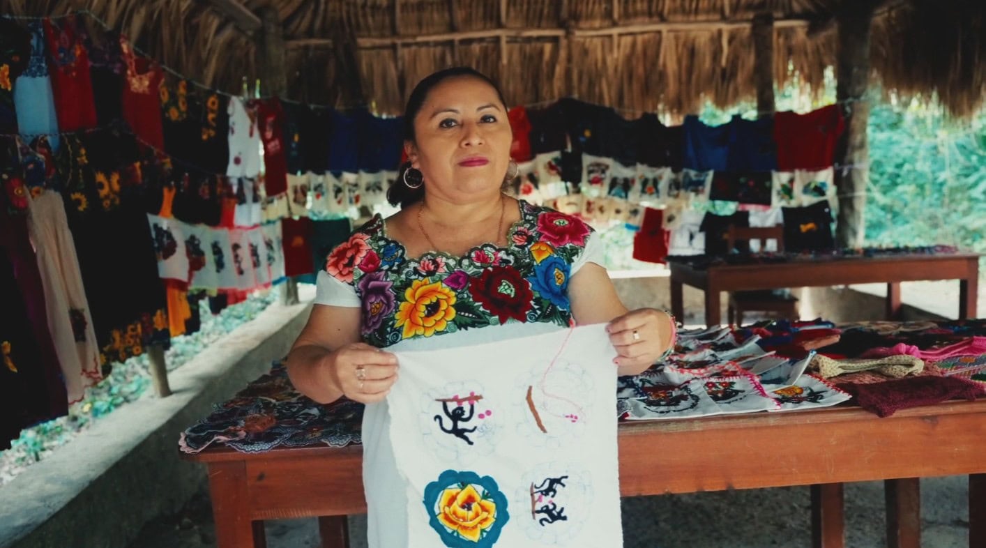 Maya woman named Rosa shows off her beautiful embroidery that she sells.